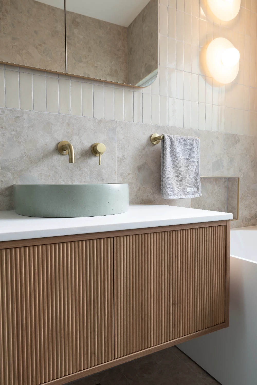 Main bathroom vanity close — mint basin and brass tap, Zellige Natural niche above.