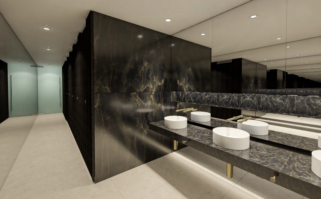 Grosvenor Place female amenities — dramatic dark veined walls and vanity with vessel basins and brass tapware.