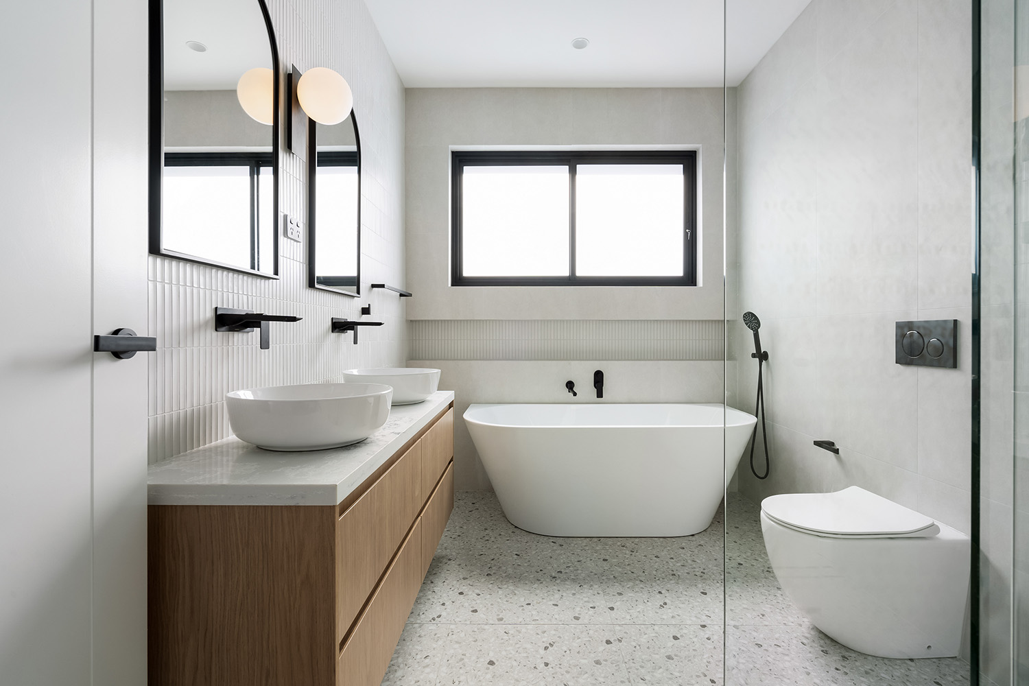 Contemporary Sydney bathroom with twin basins, terrazzo floor, kit-kat feature wall and large-format stone-look porcelain.
