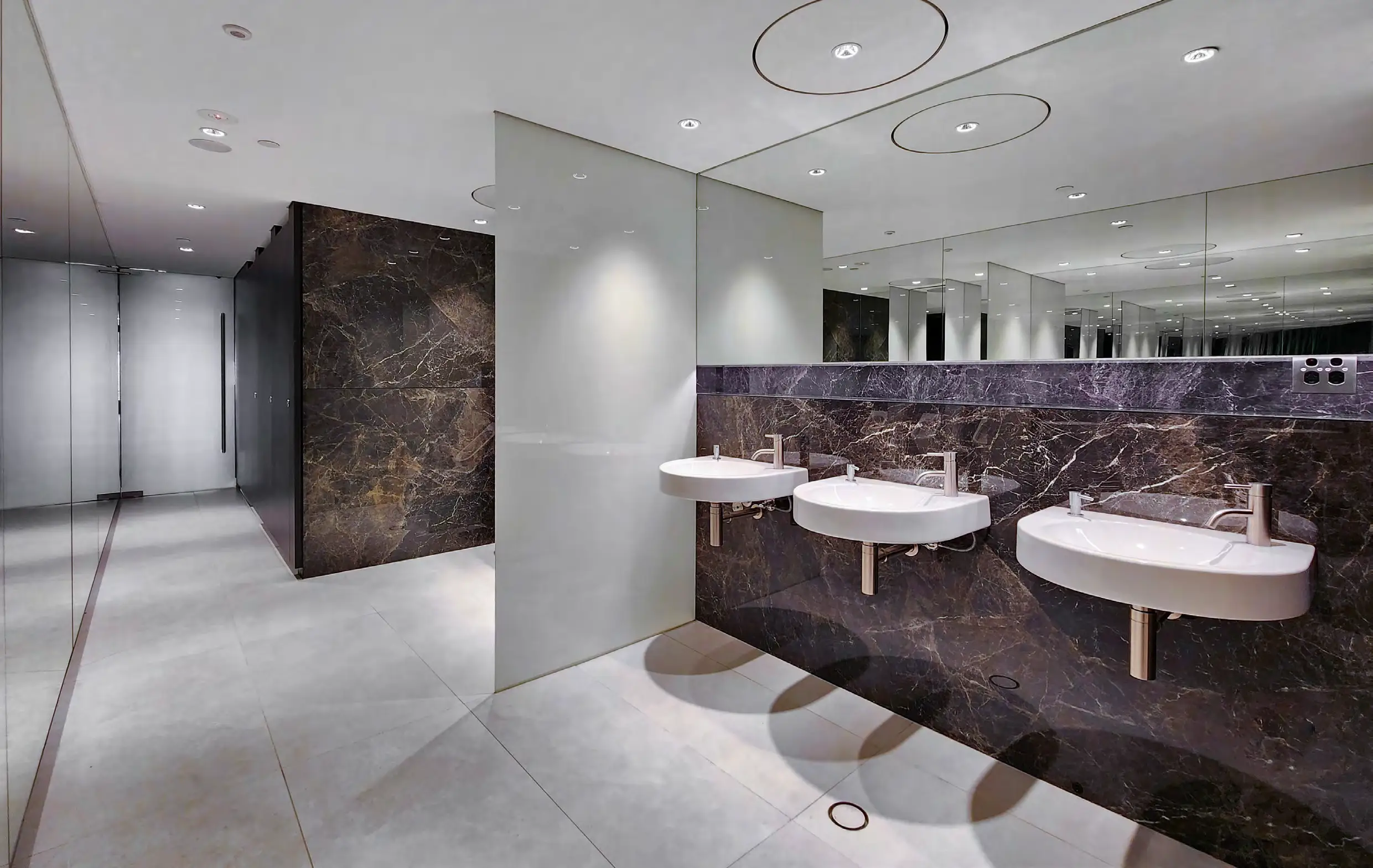 Male amenities, alternate view — light floor and crisp, calm wall surfaces.