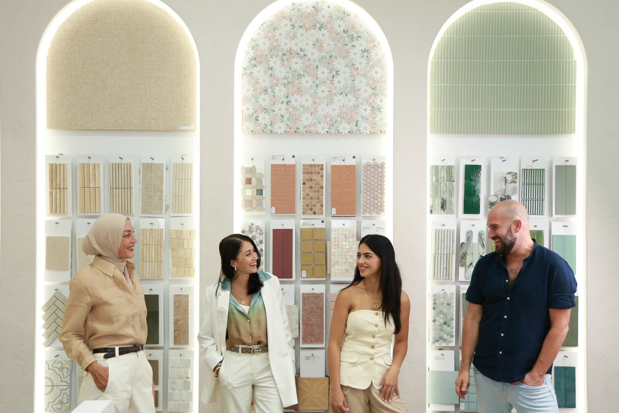 The Design Tiles design team in front of the Rockdale showroom's signature arched sample displays, backlit niches filled with curated tile paddles. The experienced Sydney team behind every free in-store terracotta consultation, in real showroom light.